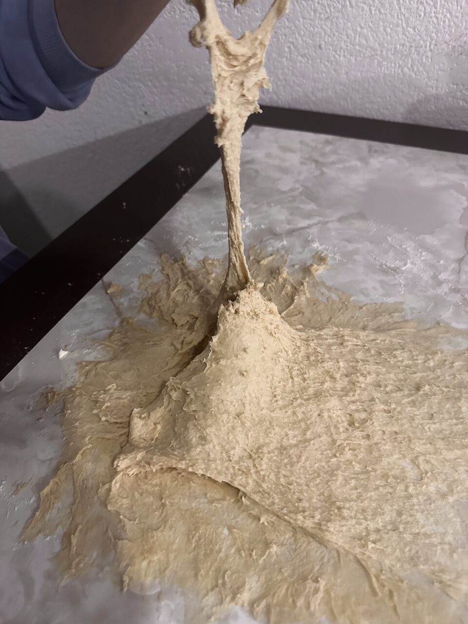 Masa pegajosa y desparramada sobre la mesa de la cocina